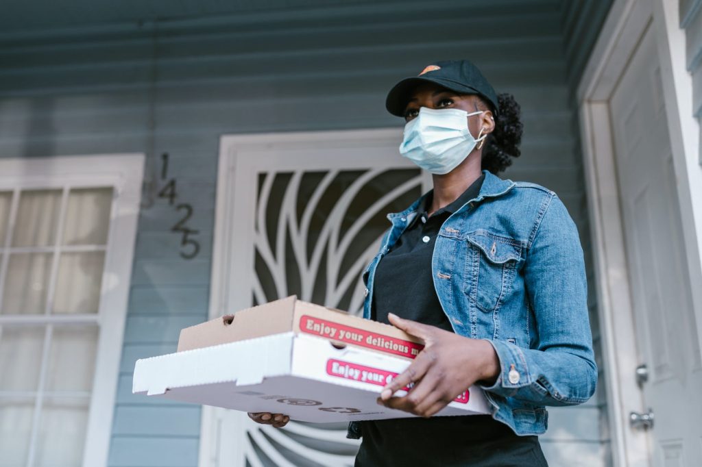 a delivery driver holding pizza boxes