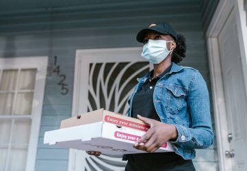 a delivery driver holding pizza boxes