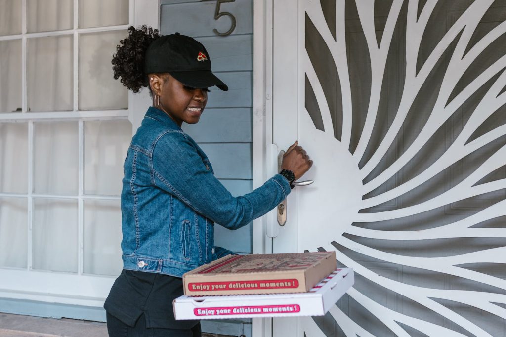 delivery driver knocks on door to deliver pizza